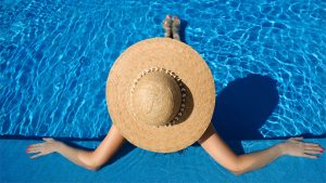 Woman in pool with sun hat